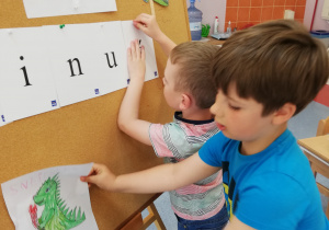 chłopcy układają napis Dinuś z liter